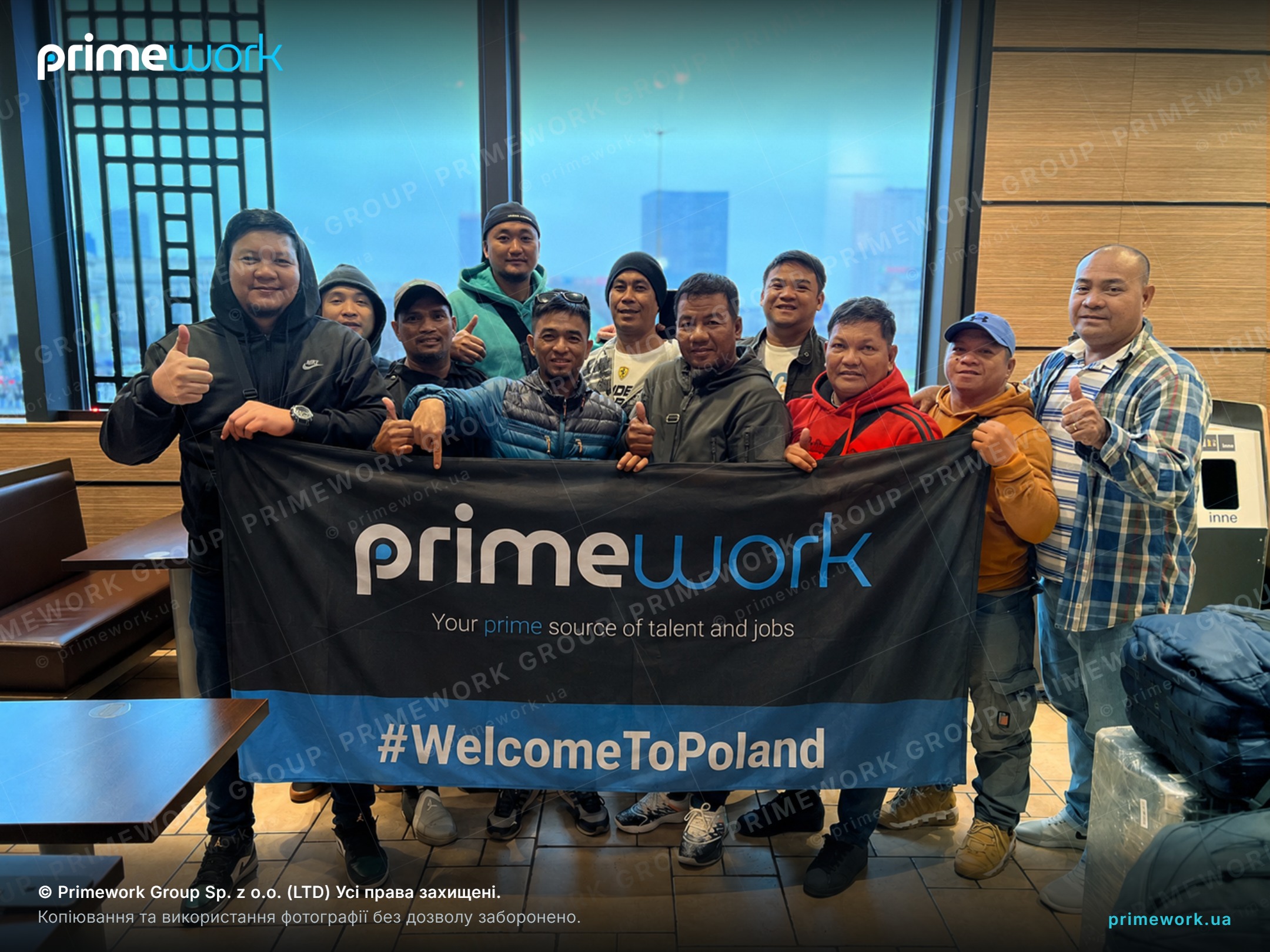 Філіппінські працівники з банером Primework у залі вокзалу після прильоту