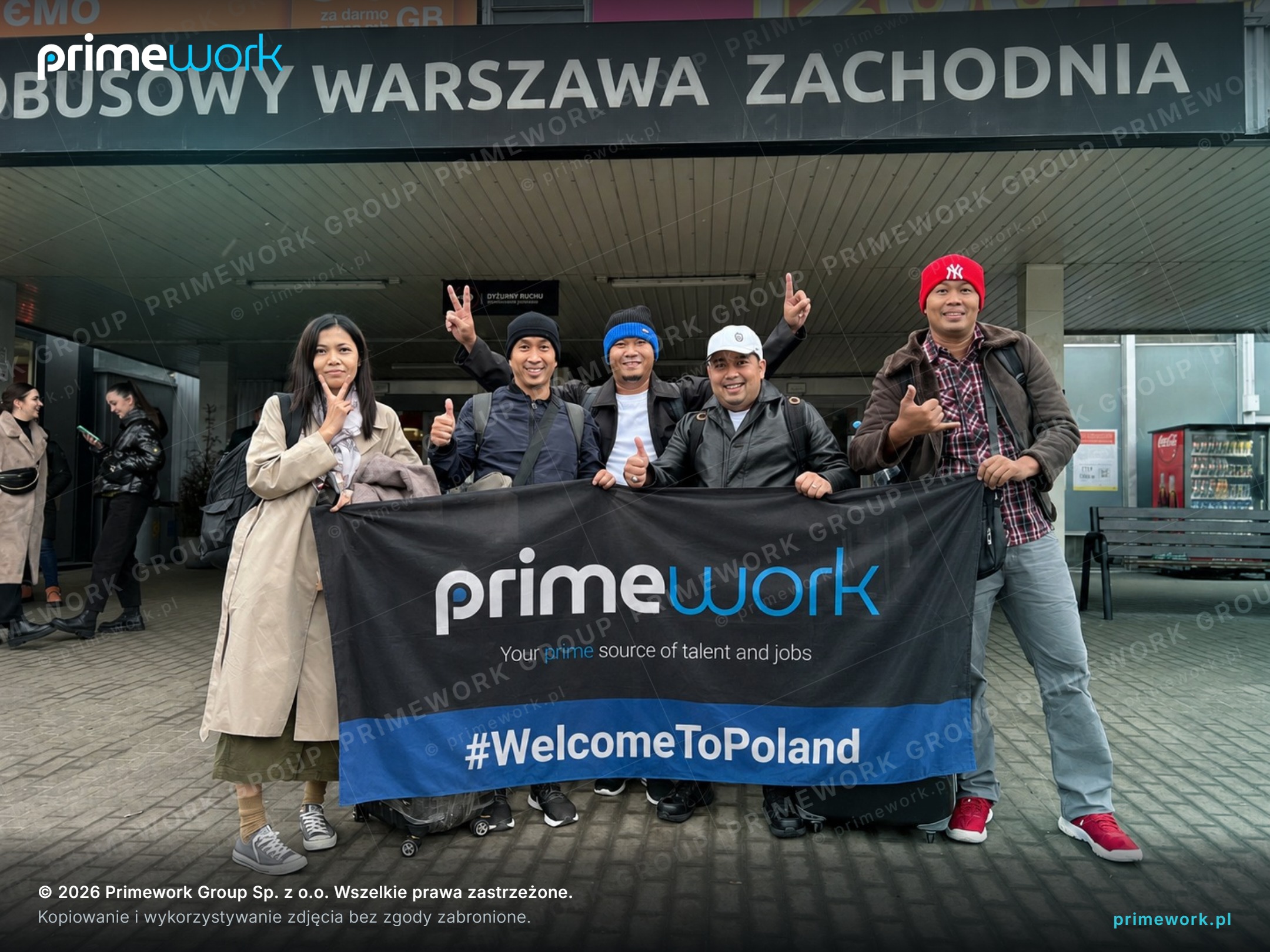Працівники з Філіппін з банером Primework на автовокзалі